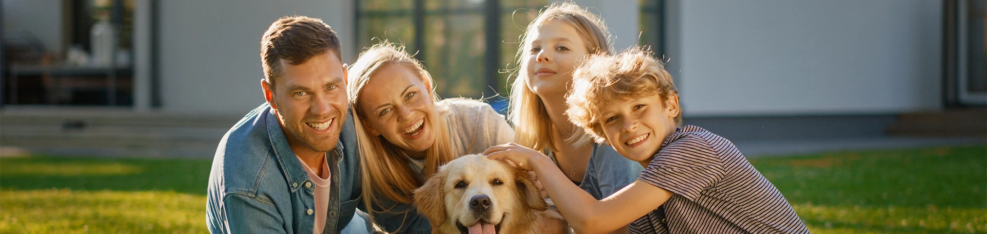 Czetroosobowa rodzina pozuje do zdjęcia z psem.
